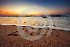 Happy New Year 2020 concept, lettering on the beach. Sea sunrise