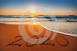 Happy New Year 2020 concept, lettering on the beach. Sea sunrise