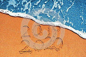 Happy New Year 2020 concept, lettering on the beach. Sea sunrise