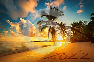 Happy New Year 2022 concept, lettering on the beach. Sea sunrise