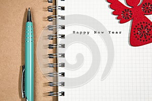 Happy New Year concept, Notebook and green pen with wooden red a