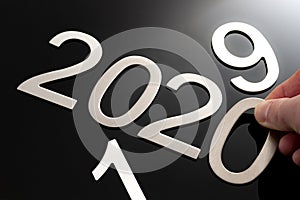 Happy new year conceptual idea with hand changing the last to digits from the number 2019 to become 2020