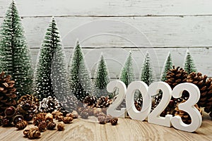 Happy New year 2023 decoration with Christmas tree and pine cones on wooden background