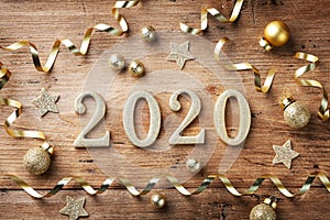 Happy New Year festive background with golden numbers 2020 and Christmas decorations on vintage wooden table top view