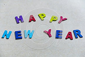 Happy new year font art colorful texting for greeting or celebrate card with light brown background,