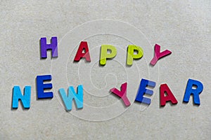 Happy new year font art colorful texting for greeting or celebrate card with light brown background,