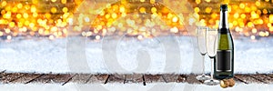 Happy new year greeting wide panorama background with bottle of champagne glasses cork on wooden planks in front  bright golden