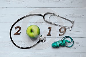 2019 Happy New Year for healthcare, Wellness and medical concept. green apple, measuring tape and wooden number