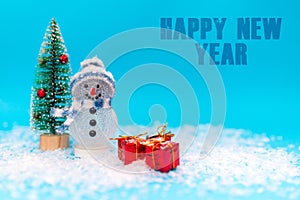 Happy New Year inscription snowman on a blue background with presents.Front view
