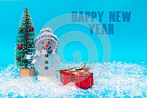 Happy New Year inscription snowman on a blue background with presents.Front view