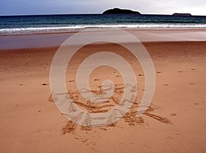 Happy New Year lettering on the beach.