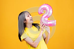 Happy new year and Merry Christmas concept. Beautiful young asian woman with balloons number 2 on yellow background