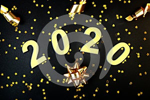2020 Happy New Year. Number 2020 written on black background. Glowing overlay template for holiday greeting card