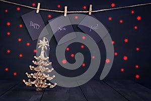 Happy new year on paper with a clothespin, hanging on a rope on a dark wooden background. Greeting card with a happy new