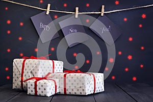 Happy new year on paper with a clothespin, hanging on a rope on a dark wooden background. Greeting card with a happy new