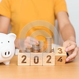 Happy New Year with piggy bank and flipping 2023 change to 2024 block. Resolution, Goals, Plan, Action, Money Saving, Retirement