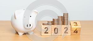 Happy New Year with piggy bank and flipping 2023 change to 2024 block. Resolution, Goals, Plan, Action, Money Saving, Retirement