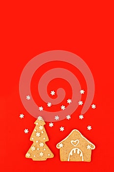 Happy New Year`s Christmas card - traditional tree and house from ginger biscuits on red background, minimal stylish seasonal