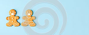 Happy New Year`s set of couple of gingerbread woman man in face mask from ginger biscuits glazed sugar icing decoration on blue