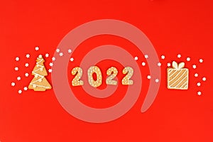 Happy New Year`s set of numbers 2022, gingerbread House and gift from ginger biscuits glazed sugar icing decoration on red