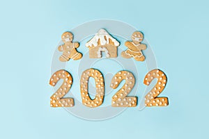 Happy New Year`s set of numbers 2022, gingerbread man in face mask from ginger biscuits glazed sugar icing decoration on blue