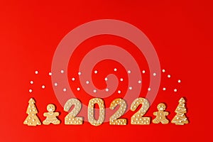 Happy New Year`s set of numbers 2022, gingerbread Tree and gift from ginger biscuits glazed sugar icing decoration on red