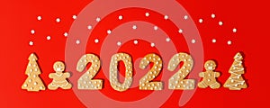 Happy New Year`s set of numbers 2022, gingerbread Tree and gift from ginger biscuits glazed sugar icing decoration on red