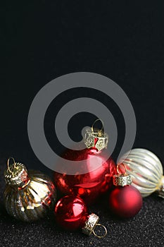 Happy New Year. Shiny Christmas tree balls on a shiny black background. A greeting card or a banner for a website. Minimalistic