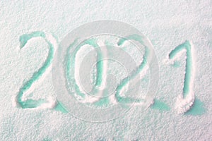 Happy new year 2021 sign text written with numbers from snow on snow surface, symbol of the next year marked against a