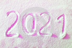 Happy new year 2021 sign text written with numbers from snow on snow surface, symbol of the next year marked against a