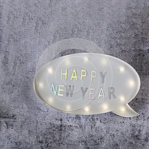 Happy New Year text in lightbox on grey minimalistic background