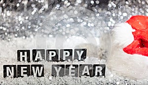 Happy new year text on snow, abstract bokeh lights background