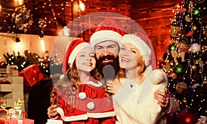 Happy New Year to you. small child and parents in santa hat. lot of xmas present boxes. Portrait loving family. Happy
