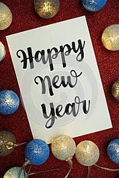 Happy New Year typography text with LED cotton ball on red glitter background