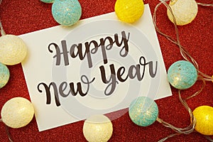 Happy New Year typography text with LED cotton ball on red glitter background