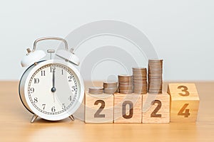 Happy New Year with vintage alarm clock and flipping 2023 change to 2024 block. Resolution, Goals, Plan, Action, Money Saving,