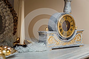 Happy New Year, vintage clock with golden dial, minutes past midnight, artificial snow. Winter holidays decorative elements