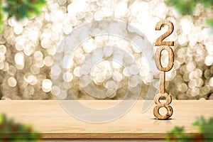Happy new year 2018 on wood table and blur Christmas tree foreground at blur sparkling gold bokeh light wall,panoramic banner for