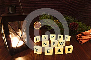 Happy New Year words with flashlight candle, star, pine branch, cinnamon and orange