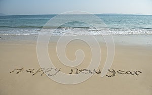 Happy new year written in beach