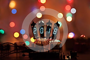 Happy new year is written with a lamp light. Radio electronic lamps. Original designed congratulation with a beautiful bokeh