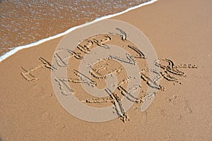 Happy new year written on sand