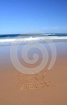 Happy new year written on sand