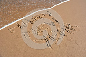 Happy new year written on sand