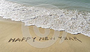 Happy new year written in sand