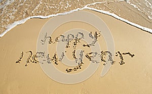 Happy new year written in sand