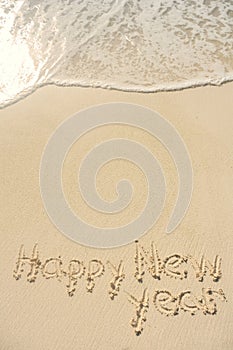 Happy New Year Written in Sand on Beach
