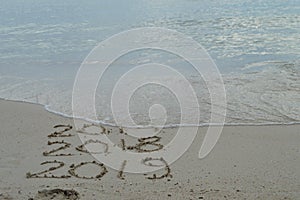 Happy New Years 2017, 2018 and 2019 handwritten on sand