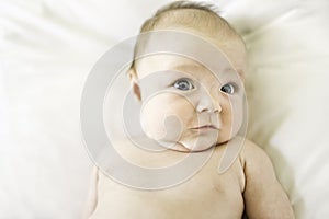 Happy newborn baby on the bed on diaper