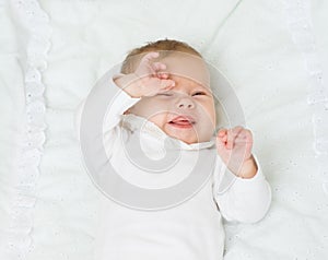 Happy newborn baby girl lying on back